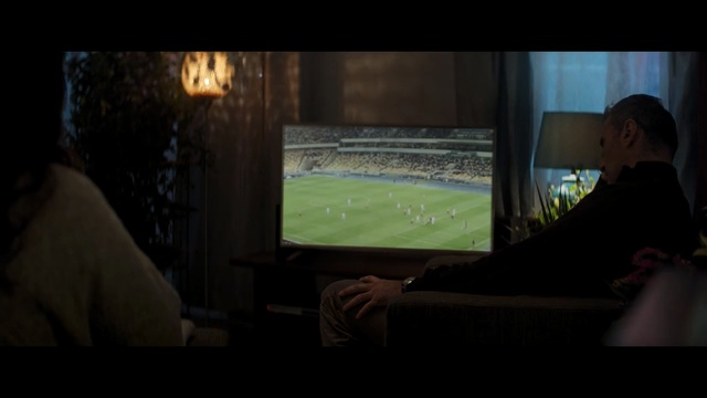 Video Reference: Darkness, Green, Light, Sport venue, Photography, Room, Night, Screenshot, Sitting, Display device