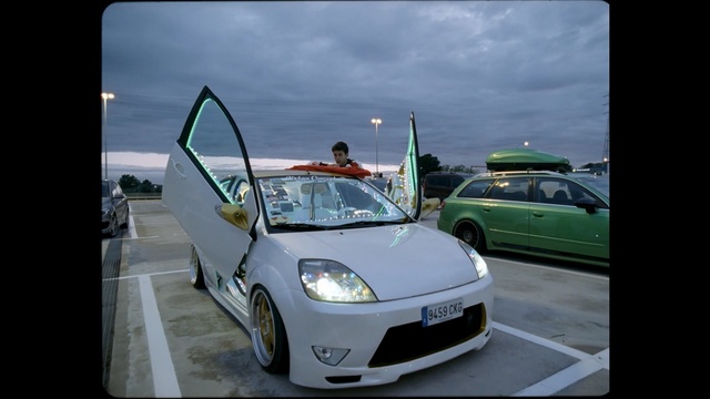 Video Reference: car, motor vehicle, white, vehicle, automotive design, mode of transport, city car, technology, wheel, family car, Person