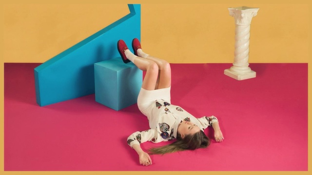 Video Reference: Pink, Arm, Leg, Joint, Human body, Human leg, Art, Indoor, Table, Sitting, Small, Dog, Yellow, Red, Laying, Toy, Front, Orange, Cat, Holding, Bed, Desk, Television, Room, Large, Woman, Man, Standing, Blue, White, Wall, Text