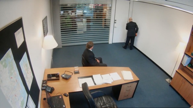 Video Reference: Office, Floor, Desk, Room, Furniture, Interior design, Architecture, Flooring, Table, Building, Person