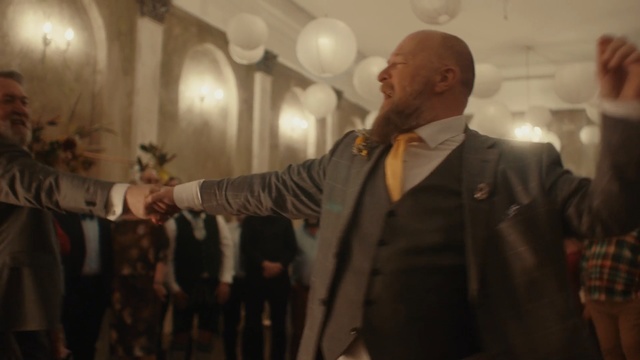 Video Reference: Photograph, Gentleman, Event, Photography, Suit, Performance, Person, Man, Indoor, Necktie, Standing, Holding, Wearing, Front, Looking, Posing, Room, Dressed, Mirror, Old, Table, People, Woman, Group, Kitchen, White, Hat, Wall, Clothing, Human face