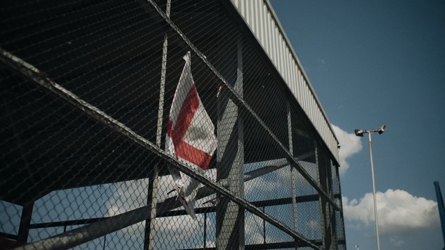 Video Reference: Architecture, Sky, Facade, Flag, Reflection, Net, Sport venue, Building, Chain-link fencing, Vehicle