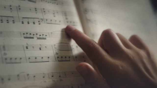 Video Reference: music, text, sheet music, light, hand, finger, close up, writing, font, line, Person