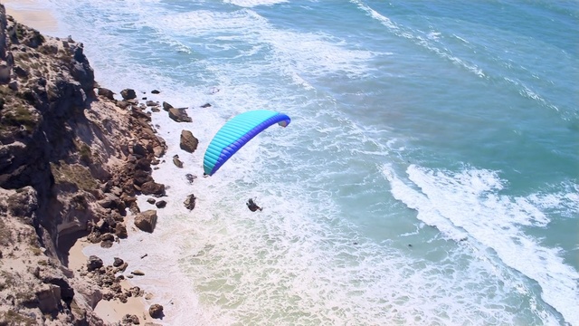 Video Reference: air sports, paragliding, sea, coastal and oceanic landforms, windsports, parachuting, coast, vacation, terrain, tourism