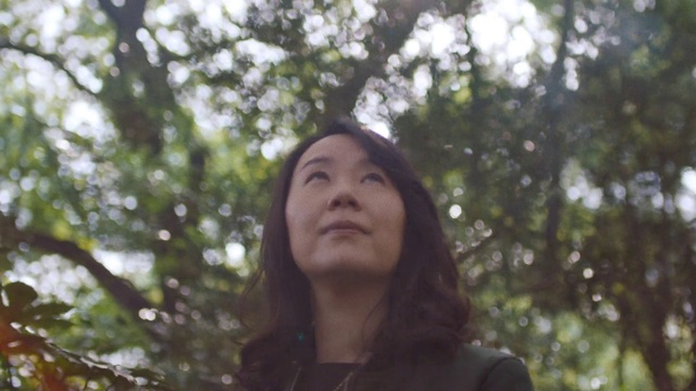 Video Reference: Hair, Face, Nature, Tree, Beauty, Natural environment, Head, Branch, Smile, Sunlight