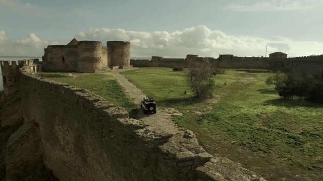 Video Reference: fortification, ruins, archaeological site, highland, sky, rural area, grass, historic site, terrain, castle