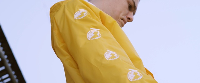 Video Reference: yellow, t shirt, sleeve, outerwear, neck, jacket, uniform