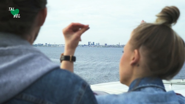 Video Reference: Tourism, Vacation, Photography, Gesture, Hand, Travel, Conversation, Person, Man, Water, Outdoor, Looking, Standing, Cellphone, Holding, Phone, Woman, Wearing, Boat, Young, People, Glasses, Shirt, Ocean, Playing, Sky, Human face, Ship, Clothing
