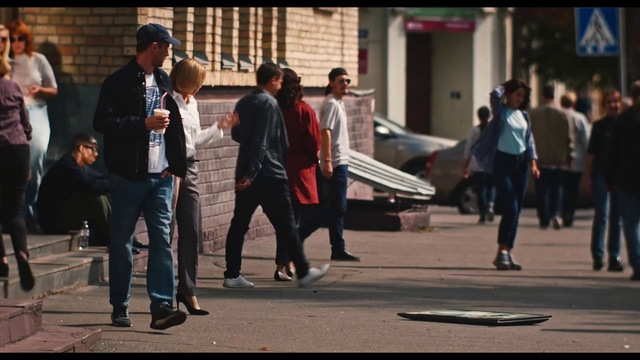 Video Reference: People, Pedestrian, Snapshot, Street, Walking, Infrastructure, Photography, Recreation, Road, City, Person, Building, Outdoor, Man, Sidewalk, Standing, Cross, Busy, Group, Woman, Talking, Young, Suit, Luggage, Crowd, Holding, Board, Suitcase, Riding, Doing, Phone, Runway, Traffic, Footwear, Clothing, Jeans, Trousers, Vehicle