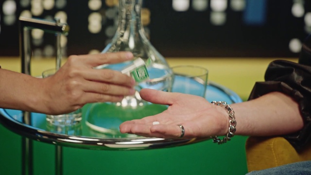 Video Reference: Water, Green, Hand, Drinking water, Person, Indoor, Table, Sitting, Holding, Woman, Plate, Food, Front, Using, Man, Eating, Shirt, Young, Glass, Bowl, White, Watch, Bottle, Wine glass