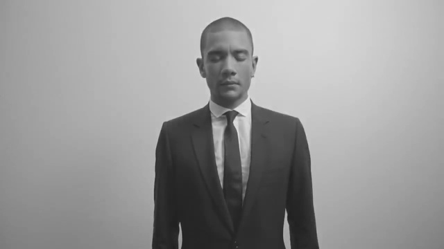 Video Reference: Suit, White, Photograph, Standing, Gentleman, Formal wear, Male, White-collar worker, Tuxedo, Outerwear, Person, Necktie, Man, Posing, Clothing, Indoor, Wearing, Photo, Front, Camera, Dressed, Young, Smiling, Holding, Dress, Business, Black, Sign, Shirt, Boy, Board, Neck, Mirror, Wall, Tie, Human face, Blazer, Coat, Collar, Dress shirt, Suit trousers, Black and white