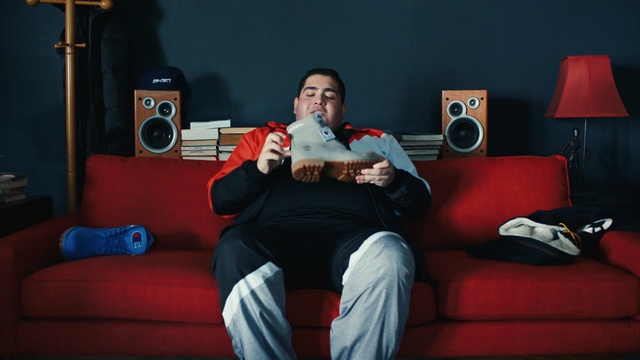 Video Reference: Red, Sitting, Room, Couch, Photography, Furniture, Electronic device, Smile, Indoor, Holding, Small, Young, Front, Man, Table, Orange, Woman, Computer, Living, Boy, Bed, Black, Wearing, Shirt, Desk, Standing, White, Bedroom, Playing, Blue, Camera, Person