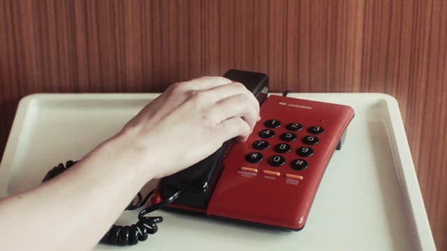 Video Reference: Red, Electronic device, Nail, Office equipment, Technology, Finger, Hand, Input device, Joystick, Play, Indoor, Remote, Person, Electronics, Control, Table, Sitting, Video, Television, White, Game, Holding, Black, Laying, Man, Phone, Wii, Computer keyboard, Office supplies, Computer, Remote control