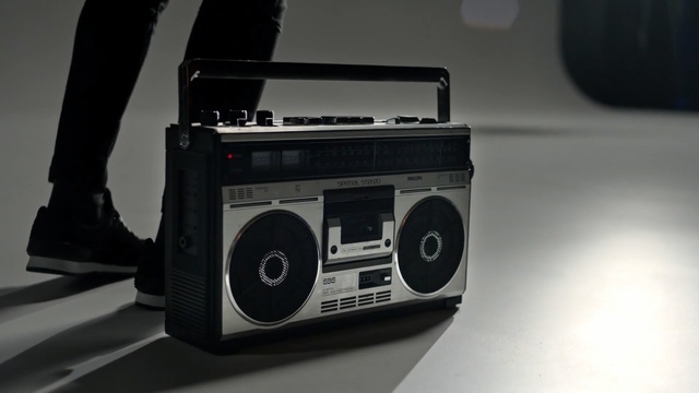 Video Reference: technology, boombox, electronics, media player, stereophonic sound, product, musical instrument accessory, audio, electronic device, audio equipment, Person