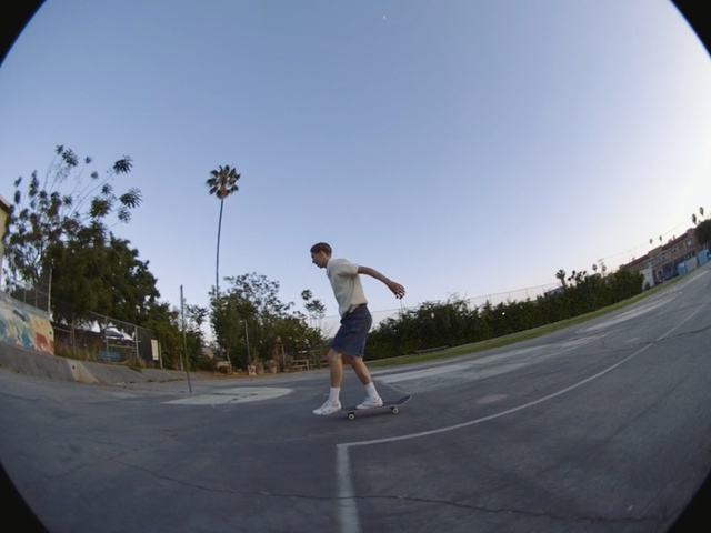 Video Reference: Skateboarding, Boardsport, Fisheye lens, Recreation, Photography, Sport venue, Kickflip, Sky, Sports equipment, Skateboard, Person, Road, Outdoor, Sport, Game, Man, Riding, Board, Court, Young, Park, Holding, Air, Ball, Trick, Ramp, Standing, Street, Doing, Playing, Player, Swinging, White, Skating, Footwear, Tree, Athletic game, Individual sports