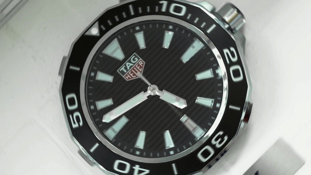 Video Reference: Analog watch, Watch, Watch accessory, Fashion accessory, Font, Brand, Strap, Emblem, Material property, Number