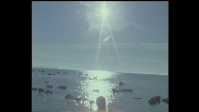 Video Reference: Sky, Atmosphere, Horizon, Water, Calm, Sea, Sunlight, Cloud, Ocean, Photography, Person, Sitting, Monitor, Beach, Man, Screen, Standing, Dark, Table, Flying, Boat, Bird, Large, Computer, Holding, Airplane, Street, Air, White, Plane, People, Riding, Kite, Text, Night sky