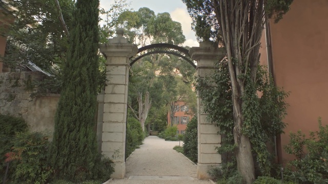 Video Reference: arch, tree, estate, plant, garden, hacienda, walkway, grass, plantation, landscape, Person
