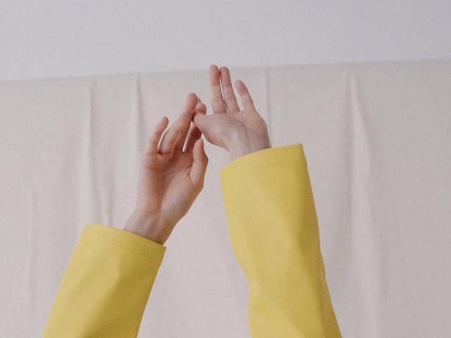 Video Reference: Yellow, Arm, Hand, Finger, Textile, Glove, Gesture, Paper