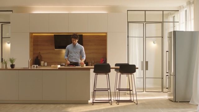 Video Reference: Furniture, Room, Desk, Bar stool, Table, Building, Material property, Interior design, Office, Chair, Indoor, Ceiling, Cabinet, Kitchen, Window, Man, Front, Mirror, Floor, Standing, Refrigerator, Area, Counter, Sink, White, Black, Living, Television, Large, Woman, Stove, Oven, Wall, Whiteboard, Stool, Coffee table, Person