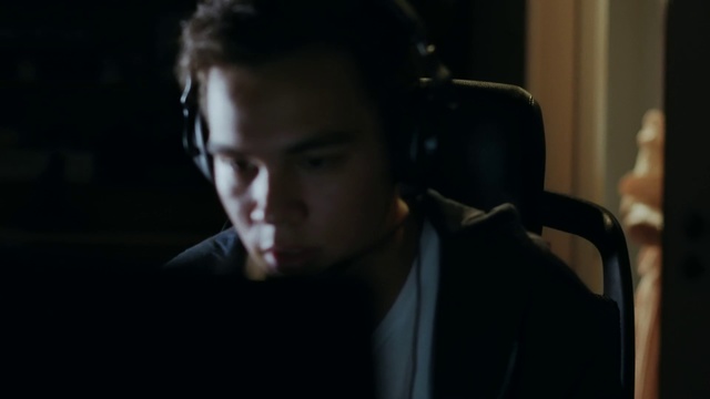 Video Reference: Gentleman, Audio equipment, Fun, Photography, Movie, Scene, Ear, Black hair, Conversation, Person, Indoor, Man, Sitting, Looking, Table, Front, Holding, Suit, Young, Glasses, Laptop, Wearing, Black, Computer, Woman, Shirt, White, Room, Plate, Standing, Phone, Human face, Wall, Portrait, Face, Screenshot, Headphones, Selfie, Dark, Clothing