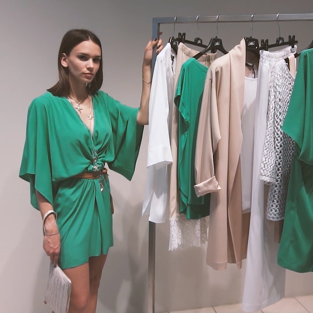 Video Reference: Clothing, Green, Dress, Turquoise, Shoulder, Fashion, Fashion design, Room, Sleeve, Boutique, Person, Indoor, Hanging, Standing, Wearing, Dressed, Clothes, Woman, Holding, Group, Large, White, Young, People, Man, Kitchen, Wall, Clothes hanger, Coat, Closet, Handbag, Skirt, Day dress, One-piece garment, Outerwear, Mantle, Robe, Costume design, Pattern (fashion design), Dry cleaning, Blouse, Mannequin