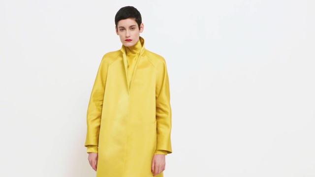 Video Reference: yellow, fashion model, coat, outerwear, jacket, neck, overcoat, Person