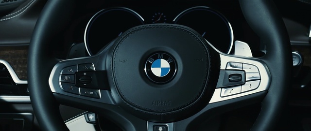 Video Reference: steering wheel, steering part, car, motor vehicle, personal luxury car, automotive design, bmw, vehicle, luxury vehicle, center console, Person