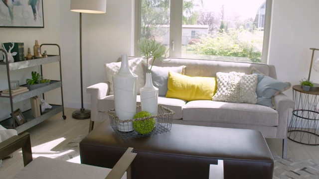 Video Reference: living room, room, furniture, home, interior design, table, house, couch, chair, window, Person