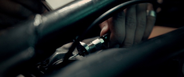 Video Reference: Vehicle door, Windshield, Auto part, Steering wheel, Vehicle, Car, Automotive design, Automotive window part, Driving, Automotive mirror, Sitting, Mirror, View, Close, Woman, Man, Reflection, Head, Motorcycle, White, Blur, Land vehicle