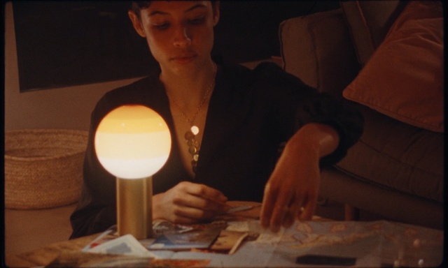 Video Reference: Lighting, Candle, Person, Indoor, Woman, Table, Holding, Front, Food, Man, Sitting, Laptop, Hand, Using, Standing, Young, Plate, White, Kitchen, Pizza, Human face, Drink, Tableware