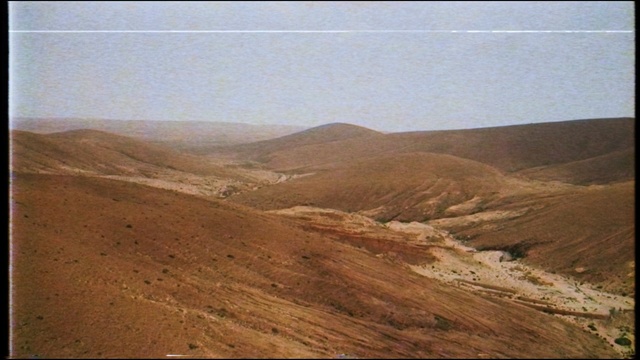 Video Reference: Mountainous landforms, Natural environment, Hill, Highland, Mountain, Ecoregion, Geology, Sky, Wadi, Landscape, Outdoor, Man, Field, Standing, View, Large, Sheep, Air, Board, White, Horse, Riding, Water, Dirt, Flying, Grazing, Group, People, Text
