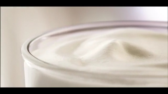 Video Reference: Cream, Food, Crème fraîche, Dairy, Milk, Lactose, Sour cream, Raw milk, Yogurt, Mousse, Indoor, Sitting, Cup, Small, Table, White, Glass, Close, Little, Laying, Computer, Water, Phone, Coffee, Plate, Cat, Drink, Tableware, Soft drink, Spoon, Abstract, Kitchen utensil, Liquid, Fluid