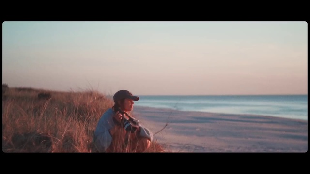 Video Reference: Horizon, Photograph, Sea, Shore, Sky, Ocean, Ecoregion, Fun, Photography, Recreation, Person, Outdoor, Man, Water, Holding, Looking, Standing, Walking, Woman, Riding, Beach, Sunset, Flying, Surfing, Kite, Clothing, Text