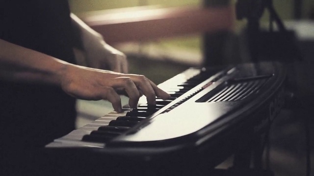 Video Reference: Pianist, Musical instrument, Musician, Piano, Electronic instrument, Musical keyboard, Music, Jazz pianist, Keyboard player, Keyboard, Indoor, Person, Sitting, Front, Man, Table, Remote, Using, Computer, Black, Holding, Desk, Control, Mouse, Blue, Electric piano, Organ, Electronic keyboard, Digital piano, Harpsichord, Spinet, Organist, Composer, Electronic musical instrument, Recital, Synthesizer, Music workstation, Electric organ