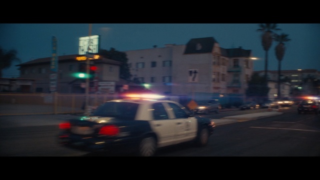 Video Reference: Car, Police car, Vehicle, Mode of transport, Police, Lighting, Metropolitan area, Night, Ford crown victoria, Urban area, Person, Road, Outdoor, Street, Traffic, Light, Driving, Highway, Going, Riding, Red, City, Busy, Intersection, Truck, Traveling, Man, White, Rain, Blurry, Land vehicle, Text, Way, Wheel, Vehicle registration plate