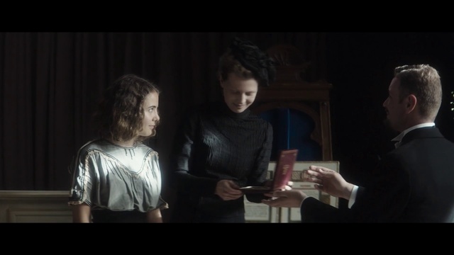 Video Reference: Photograph, Social group, Darkness, Fun, Conversation, Lady, Snapshot, Gentleman, Scene, Interaction, Person, Man, Indoor, Window, Looking, Sitting, Standing, Table, Front, People, Piano, Holding, Food, Woman, Young, Video, Screen, Room, Group, Playing, Human face, Clothing, Screenshot, Portrait, Smile