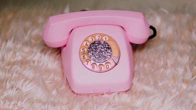 Video Reference: Pink, Product, Telephone, Corded phone, Telephony, Electronic device, Watch, Person, Indoor, Container, Sitting, Plastic, Cake, Table, Small, Basket, Box, Food, Filled, Remote, Little, White, Brush, Bowl, Plate, Cheese, Playing, Cloth