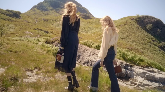 Video Reference: Wilderness, Outerwear, Hill, Photography, Landscape, Mountain, Rock, Outdoor, Grass, Nature, Man, Standing, Young, Field, Wearing, Green, Board, Flying, White, Riding, Holding, Air, Sky, Clothing, Person, Hiking, Woman, Footwear, Smile, Trousers, Highland