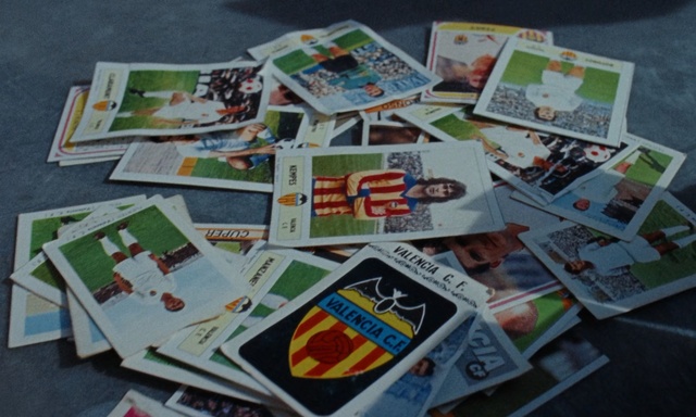 Video Reference: Games, Recreation, Collection, Queen, Newspaper, Text, Appliance, Refrigerator, Child, Small, Little, Table, Photo, Girl, Young, Toy, Covered, Paper, Sitting, Boy, Bear, Many, Lot, Stuffed, Dog, Birthday, Cake, Old, Holding, Bed, Group, Room, Fire, Book, Cartoon, White goods, Messy, Envelope, Cluttered, Family