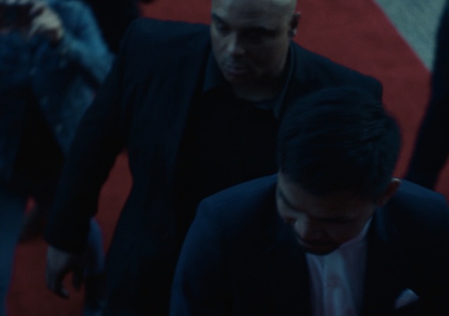 Video Reference: Blue, Human, Screenshot, Fun, Room, Photography, Darkness, Fictional character, Person, Man, Indoor, Sitting, Looking, Table, Laptop, Front, People, Computer, Using, Holding, Dark, Standing, Young, Group, Suit, Woman, Shirt, Playing, Human face, Clothing, Crowd