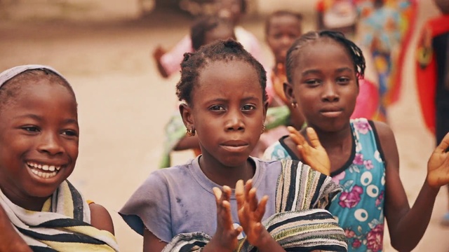Video Reference: People, Child, Adaptation, Community, Smile, Happy, Person, Boy, Young, Table, Standing, Little, Food, Holding, Photo, Smiling, Group, Sitting, Girl, Woman, Man, Game, Plate, Eating, Playing, Phone, White, Shirt, Pizza, Human face, Toddler, Baby, Clothing, Investor, Crowd