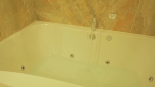 Video Reference: bathtub, property, tile, plumbing fixture, floor, bathroom, jacuzzi, angle, bathroom sink, flooring