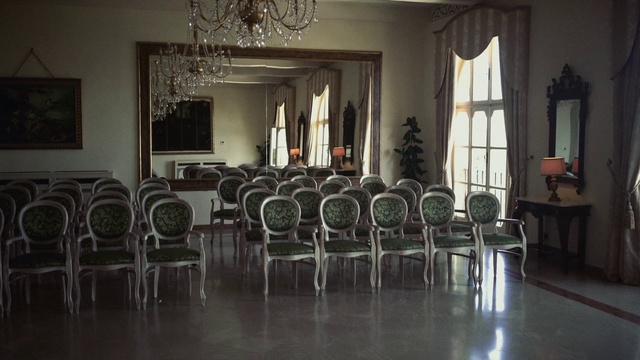 Video Reference: Room, Chair, Furniture, Building, Waiting room, Architecture, Table, Interior design, City, Hall