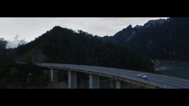 Video Reference: Bridge, Nature, Highland, Sky, Water, Mountain, Infrastructure, Landscape, Road, Cloud