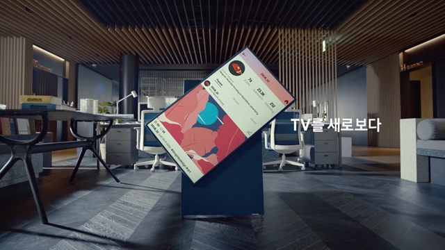 Video Reference: Signage, Architecture, Design, Floor, Banner, Interior design, Advertising, Flooring, Building, Graphics, Indoor, Ceiling, Table, Room, Sitting, Window, Living, Chair, Computer, Area, White, Furniture, Desk, Wooden, Black, Large, Kitchen, Laptop, Remote, Television, Holding, Standing, Video, Man, Wii, Playing, People, Exhibition, Text, Innovation