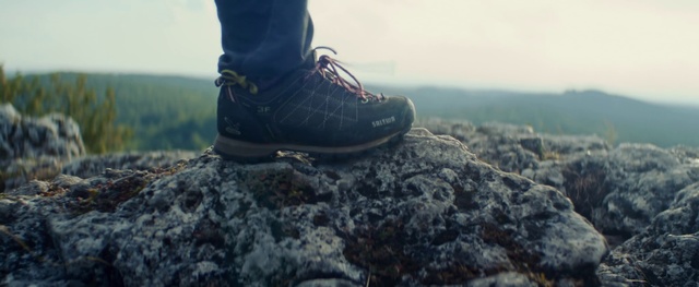 Video Reference: Footwear, Shoe, Hiking boot, Sky, Outdoor shoe, Rock, Adventure, Grass, Tree, Cleat