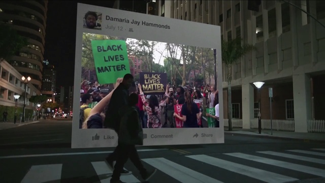 Video Reference: pedestrian, infrastructure, advertising, street, road, urban area, city, vehicle, protest, crowd, Person