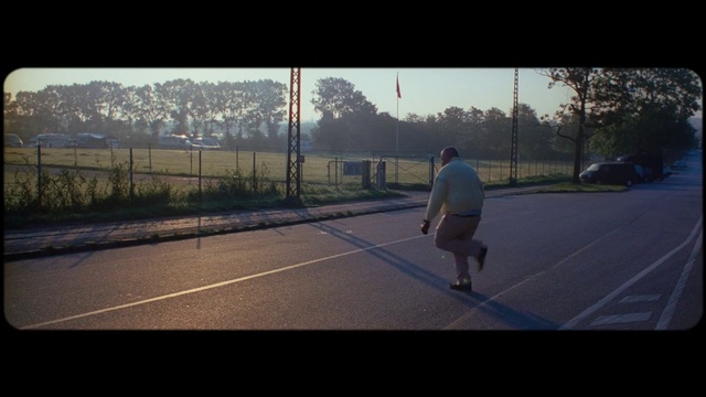 Video Reference: Tennis court, Sport venue, Atmospheric phenomenon, Sky, Morning, Line, Asphalt, Atmosphere, Photography, Net, Outdoor, Sport, Game, Road, Man, Photo, Basketball, Dark, Street, Walking, Riding, Standing, Holding, Court, Board, City, Young, Cloudy, Playing, Ball, Skiing, Player, Air, Athletic game, Text, Tree, Person, Footwear, Day