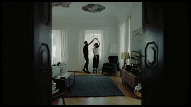 Video Reference: Photograph, Room, Property, Snapshot, Interior design, Photography, Floor, Building, House, Ceiling, Indoor, Table, Window, Dark, Small, Sitting, White, Mirror, Living, Door, Desk, Fireplace, Bed, Black, Bedroom, Refrigerator, Kitchen, Wall, Furniture, Chair, Couch, Vase, Coffee table, Sofa bed, Curtain